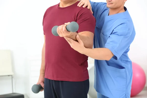 Starší muž dělá cvičení pod dohledem fyzioterapeuta, closeup — Stock fotografie