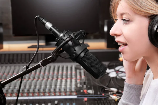 Θηλυκό ραδιο οικοδεσπότης που εκπέμπουν μέσω μικροφώνου στο studio — Φωτογραφία Αρχείου