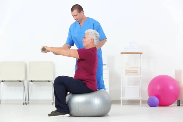 Physiotherapist working with patient in rehabilitation centre — Stock Photo, Image