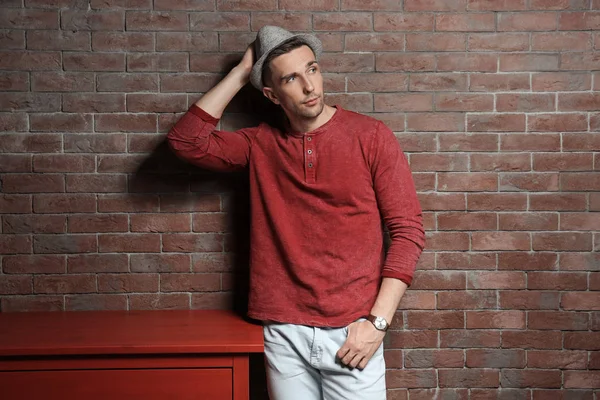Yakışıklı genç adamın yanında tuğla duvar portresi