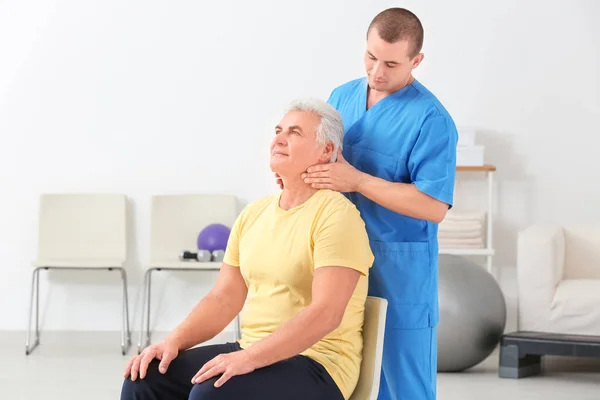 Fisioterapeuta trabajando con el paciente en el centro de rehabilitación —  Fotos de Stock