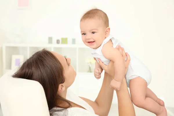 Retrato de una joven madre jugando con un lindo bebé en casa —  Fotos de Stock
