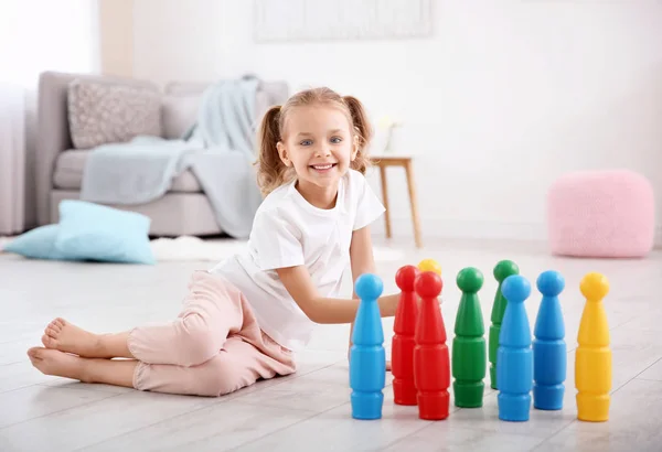 Nettes kleines Mädchen spielt zu Hause mit Kegeln — Stockfoto