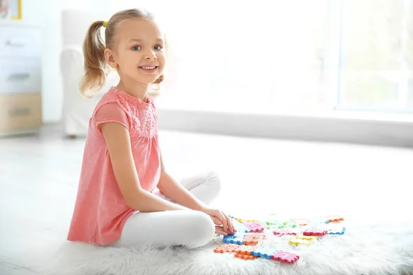 Schattig klein meisje spelen met pazzles thuis — Stockfoto