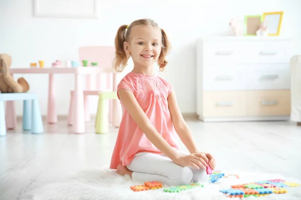 Cute little girl playing with pazzles at home — Stock Photo, Image