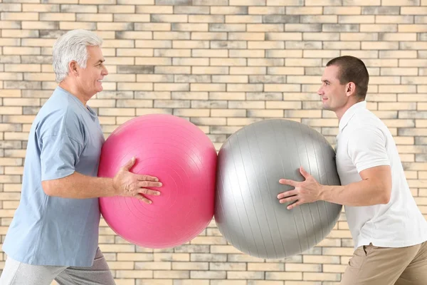 Fysiotherapeut werken met patiënt op bakstenen muur achtergrond — Stockfoto