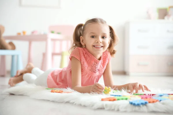 Menina bonito brincando com pazzles em casa — Fotografia de Stock