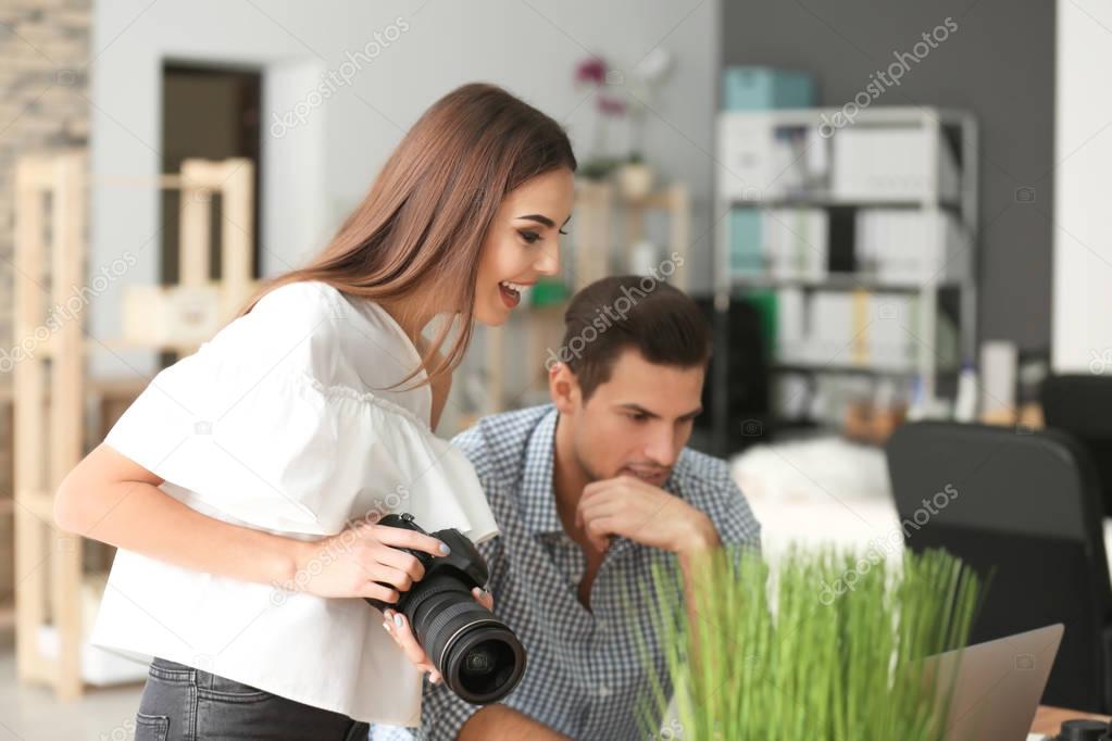 Young photographers with camera in office