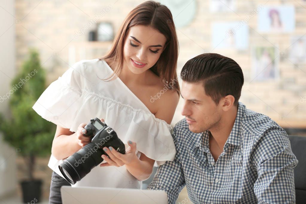 Young photographers with camera in office