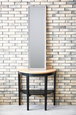 Stand tuğla duvarının yakınında modern ayna