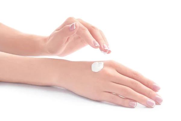 Mujer joven aplicando crema de manos sobre fondo blanco —  Fotos de Stock