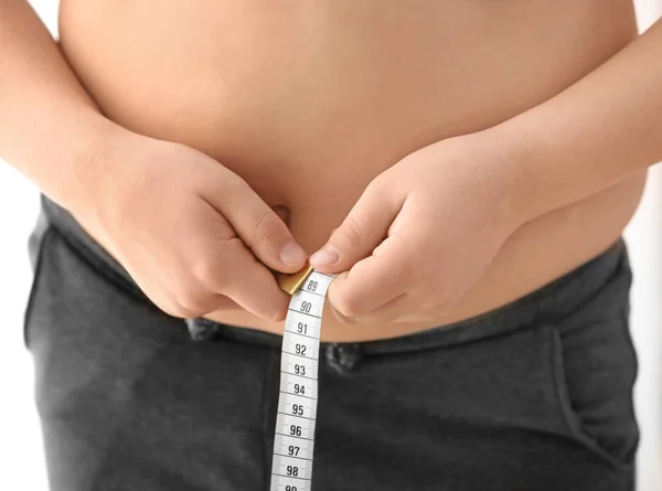 Niño con sobrepeso midiendo cintura — Foto de Stock