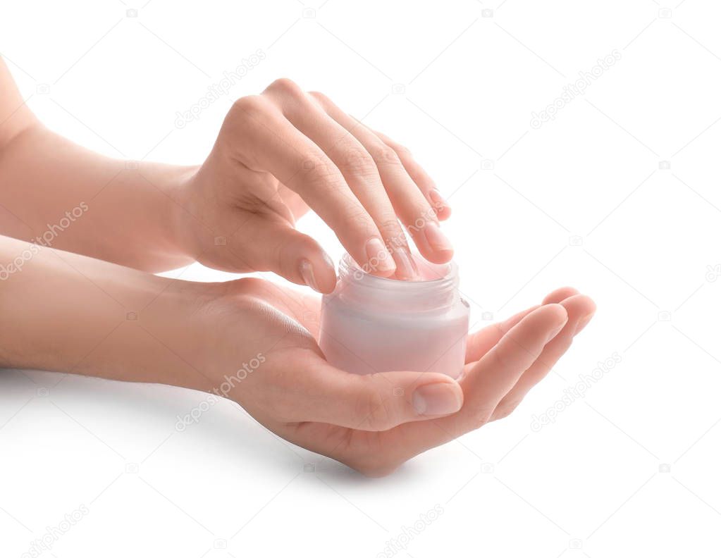 Young woman with jar of hand cream on white background