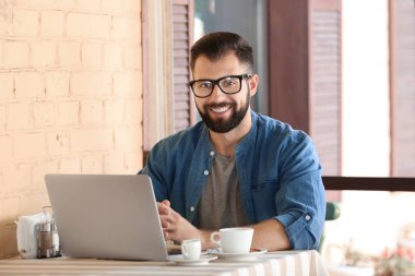 Genç blogger Cafe mekanlarda dizüstü bilgisayar kullanarak