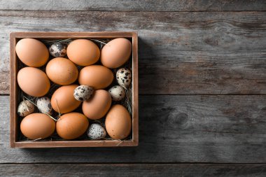 Ahşap masa kutusunda bıldırcın ve tavuk yumurta