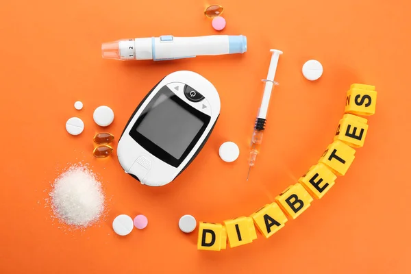 Composition with word "Diabetes", medicaments and digital glucometer on color background — Stock Photo, Image