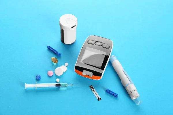 Цифровой глюкометр, ручка ланцета, шприц и медикаменты на цветном фоне. Управление диабетом — стоковое фото