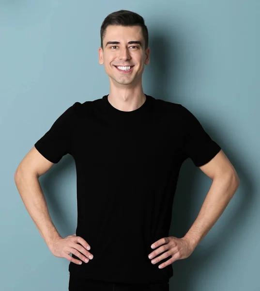 Молодий чоловік у чорній футболці на кольоровому фоні. Макет для дизайну — стокове фото
