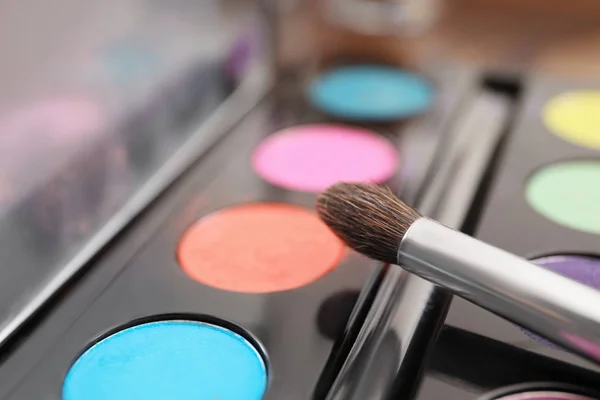 Eyeshadow palette with brush of professional makeup artist, closeup