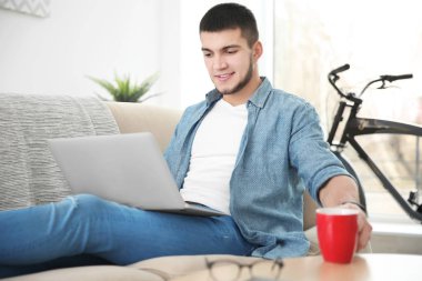 Genç adam dizüstü bilgisayar kullanıyor 