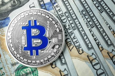 Silver bitcoin on dollar bills  clipart
