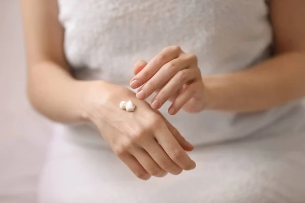 Mujer joven aplicando crema de manos, primer plano — Foto de Stock