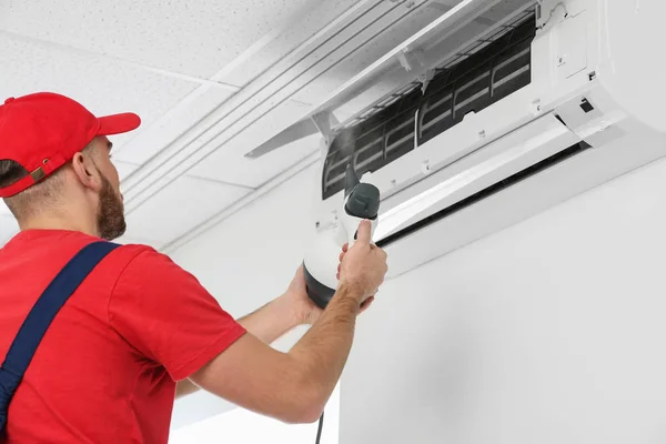 Técnico masculino limpieza aire acondicionado interior — Foto de Stock