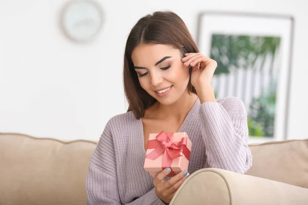 Beautiful young woman with gift — Stock Photo, Image