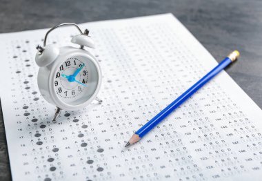 Sınav formu, kalem ve çalar saat tablo