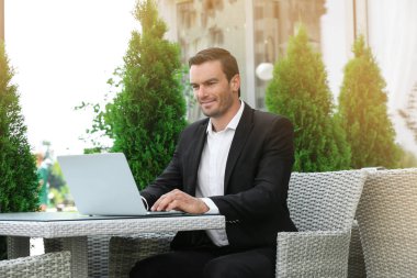 Sokak kafede dizüstü bilgisayar kullanan adam