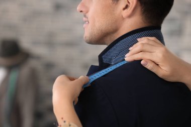 Atelier içinde müşterinin ölçümleri alarak terzi