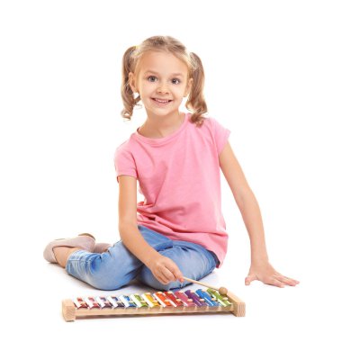 Sevimli küçük kız ksilofon beyaz arka plan üzerinde oynama