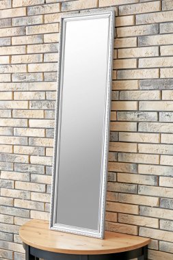 Stand tuğla duvarının yakınında modern ayna