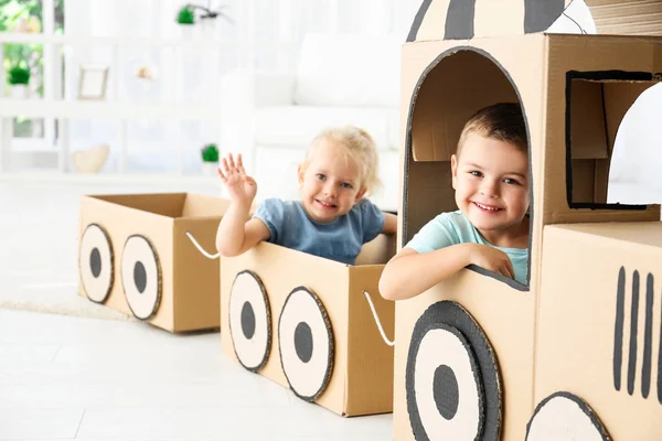 Маленькие дети играют с картонным поездом в светлом помещении — стоковое фото