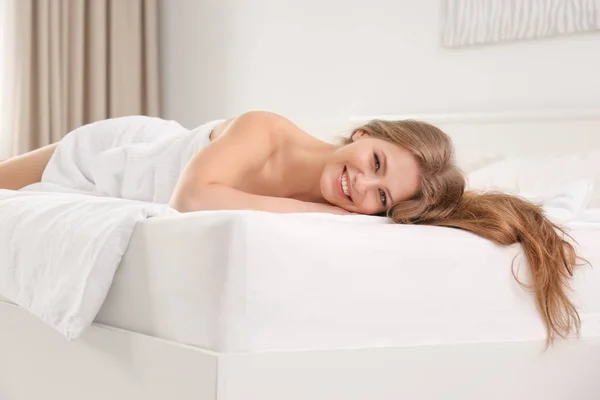 Young woman lying on bed — Stock Photo, Image