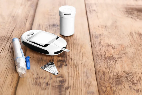 Glucometro digitale, penna lancetta e medicamenti su fondo di legno. Gestione del diabete — Foto Stock