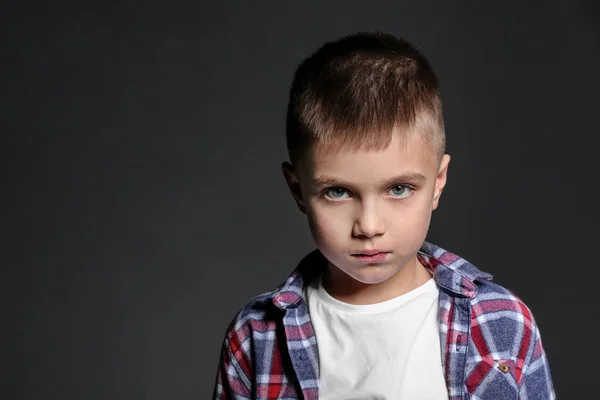 Triste petit garçon victime d'intimidation à l'école sur fond sombre — Photo
