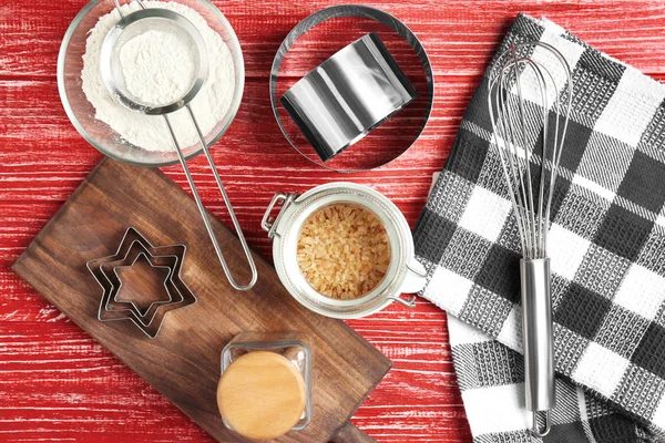 Kitchen utensils and ingredients for pastries on color wooden background