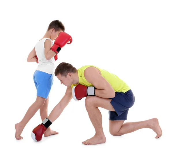 Bonito menino treinando com treinador de boxe, em fundo branco — Fotografia de Stock