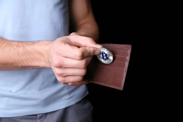Людина вкладає bitcoin в гаманець — стокове фото
