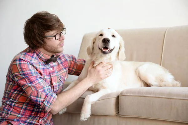 Bello giovane hipster con cane a casa — Foto Stock