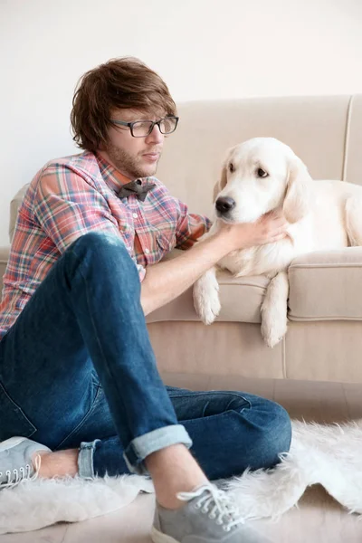 Bello giovane hipster con cane a casa — Foto Stock