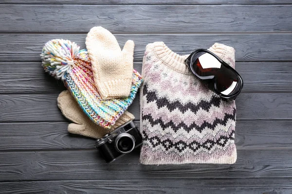 スキーのゴーグルと木製の背景の写真カメラの暖かい服 冬の休暇の概念 — ストック写真