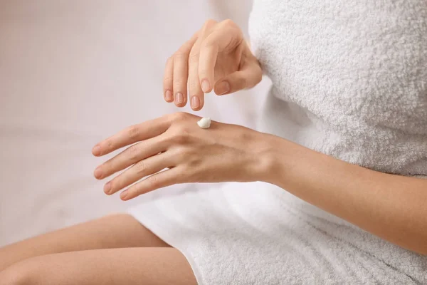 Mujer joven aplicando crema de manos, primer plano —  Fotos de Stock