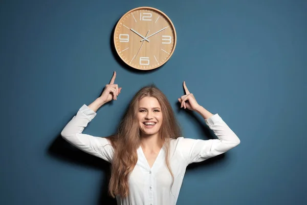Beautiful manager pointing at clock