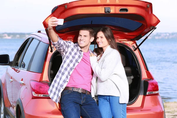 Pareja Joven Tomando Selfie Cerca Coche Moderno Aire Libre —  Fotos de Stock