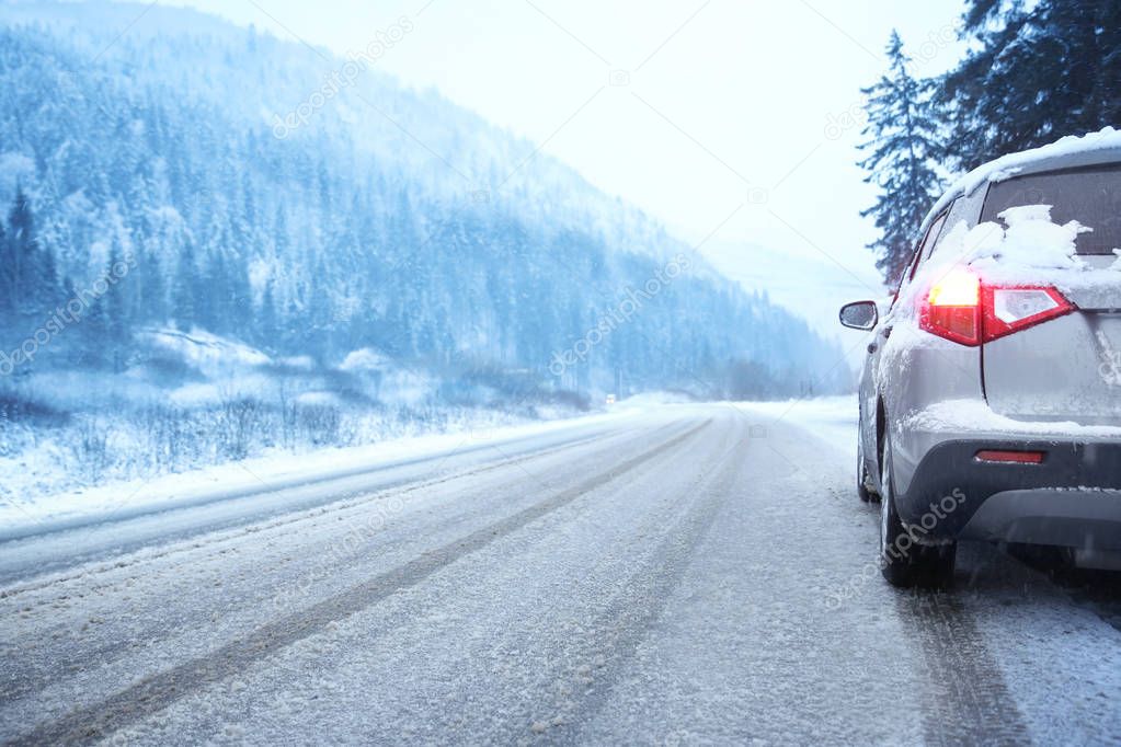 Car on country road in snowy winter day