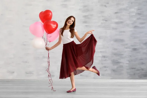 Giovane donna con palloncini a forma di cuore — Foto Stock