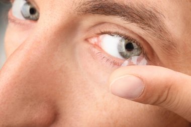 Onun gözünde, closeup koyarak Kontakt lens genç adam