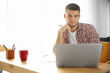 Genç adam dizüstü bilgisayar kullanıyor